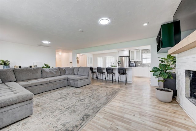 2401 Big Cedar Ave, Edmond, OK 73012 - living area with light wood-type flooring, recessed lighting, and a fireplace
