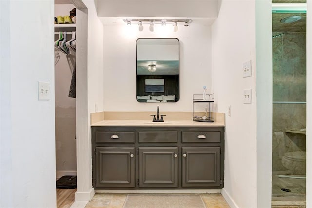 2401 Big Cedar Ave, Edmond, OK 73012 - full bath featuring track lighting, vanity, a shower stall, and a spacious closet
