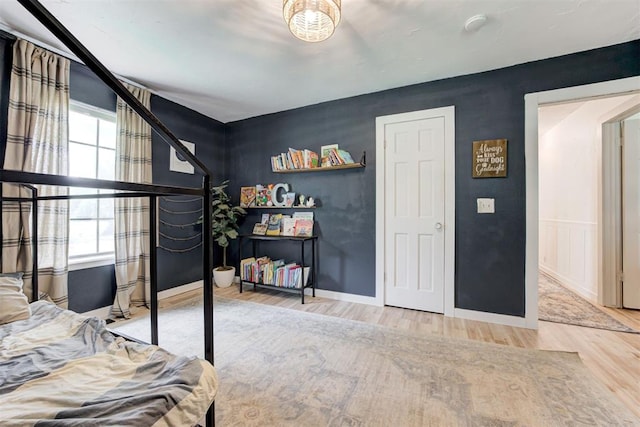 2401 Big Cedar Ave, Edmond, OK 73012 - bedroom featuring wood finished floors and multiple windows