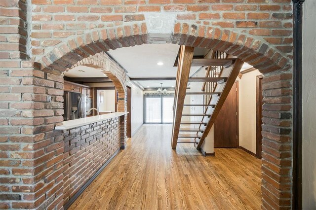 3824 Key Pl, Oklahoma City, OK 73112 - hall with arched walkways, light wood-style floors, stairway, brick wall, and crown molding