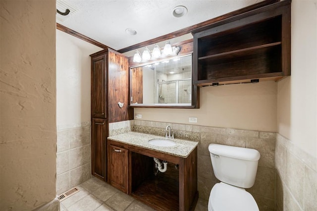 3824 Key Pl, Oklahoma City, OK 73112 - full bath featuring tile walls, wainscoting, vanity, ornamental molding, and tile patterned flooring