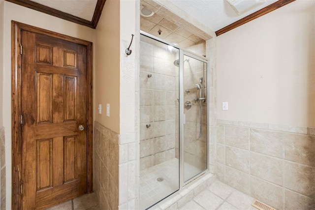 3824 Key Pl, Oklahoma City, OK 73112 - bathroom featuring tile walls, crown molding, a stall shower, tile patterned floors, and wainscoting