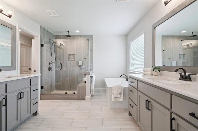 512 NW 186th St, Edmond, OK 73012 - full bathroom with a shower stall, two vanities, a freestanding tub, and recessed lighting