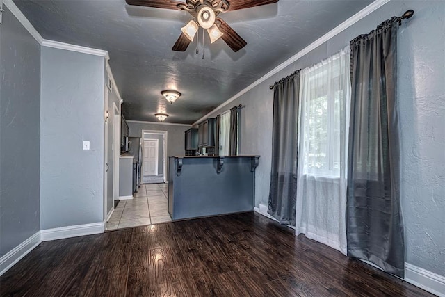 2100 Barclay Rd, Oklahoma City, OK 73120 - unfurnished living room with wood finished floors, ornamental molding, a ceiling fan, and a textured wall