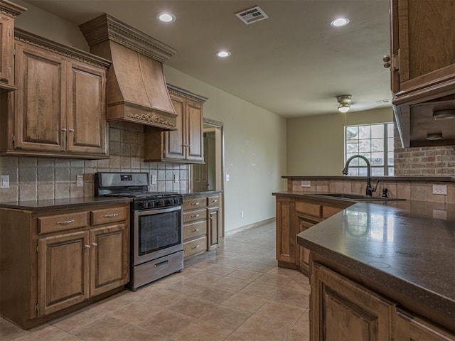 8409 NW 106th St, Oklahoma City, OK 73162 - kitchen featuring stainless steel range with gas cooktop, custom range hood, dark countertops, decorative backsplash, and recessed lighting
