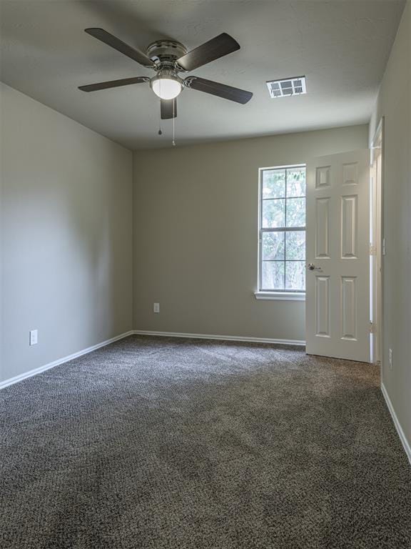 8409 NW 106th St, Oklahoma City, OK 73162 - spare room with a ceiling fan and dark carpet