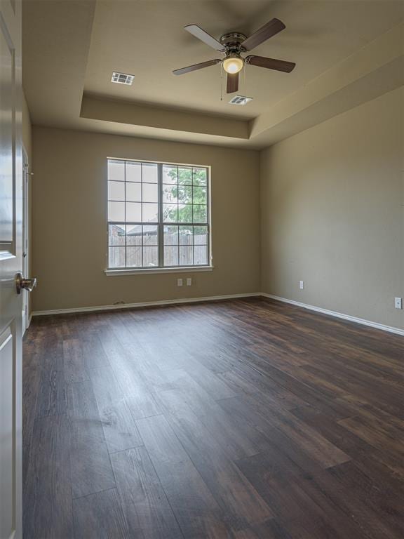 8409 NW 106th St, Oklahoma City, OK 73162 - spare room with a tray ceiling, dark wood finished floors, and ceiling fan