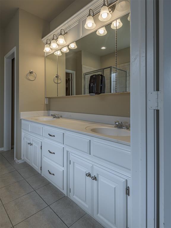 8409 NW 106th St, Oklahoma City, OK 73162 - full bathroom featuring tile patterned flooring, double vanity, and an enclosed shower