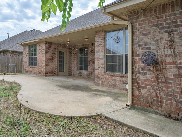 8409 NW 106th St, Oklahoma City, OK 73162 - back of house with roof with shingles, brick siding, and a patio area