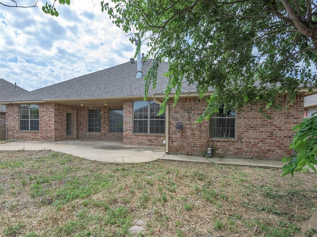 8409 NW 106th St, Oklahoma City, OK 73162 - rear view of house with a patio, roof with shingles, and brick siding