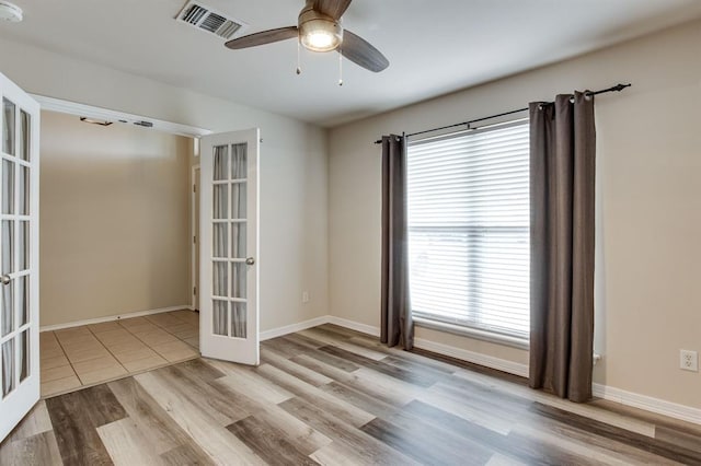 2113 SE 8th St, Moore, OK 73160 - empty room with french doors, ceiling fan, wood finished floors, and healthy amount of natural light