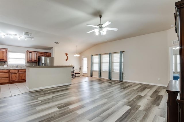 2113 SE 8th St, Moore, OK 73160 - unfurnished living room featuring plenty of natural light, light wood-style flooring, a ceiling fan, lofted ceiling, and a chandelier