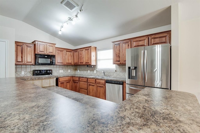 2113 SE 8th St, Moore, OK 73160 - kitchen featuring stainless steel appliances, vaulted ceiling, decorative backsplash, and brown cabinets