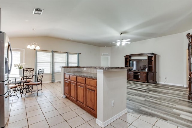 2113 SE 8th St, Moore, OK 73160 - kitchen with freestanding refrigerator, light tile patterned floors, a ceiling fan, a chandelier, and healthy amount of natural light