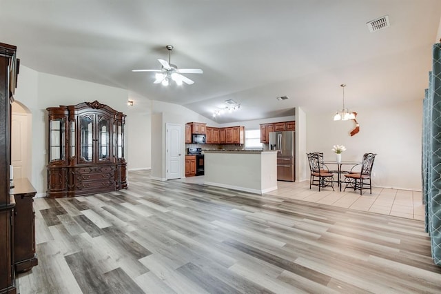 2113 SE 8th St, Moore, OK 73160 - unfurnished living room featuring ceiling fan, lofted ceiling, light wood finished floors, arched walkways, and a chandelier