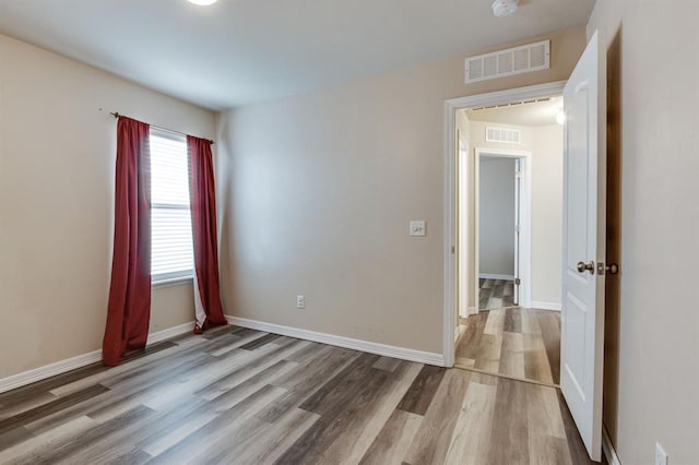 2113 SE 8th St, Moore, OK 73160 - empty room with wood finished floors and a smoke detector
