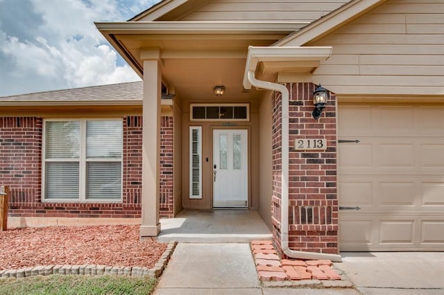 2113 SE 8th St, Moore, OK 73160 - doorway to property with brick siding, an attached garage, and roof with shingles