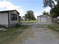 515 Logan Ave, Cashion, OK 73016 - view of side of property featuring a detached garage, driveway, and an outbuilding