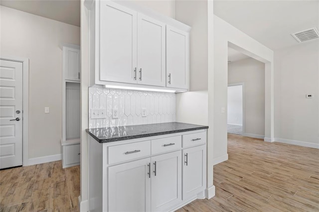 1244 Layla Ln, Blanchard, OK 73010 - kitchen with decorative backsplash, light wood-style flooring, white cabinets, and dark stone counters