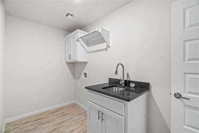 1244 Layla Ln, Blanchard, OK 73010 - washroom featuring washer hookup, light wood-type flooring, and cabinet space