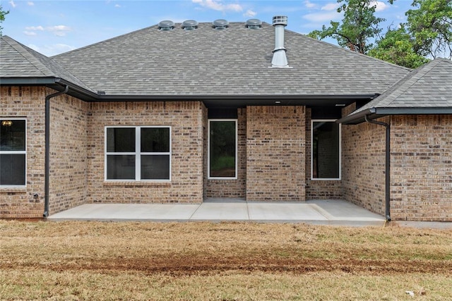 1244 Layla Ln, Blanchard, OK 73010 - back of property featuring roof with shingles, a patio area, and brick siding