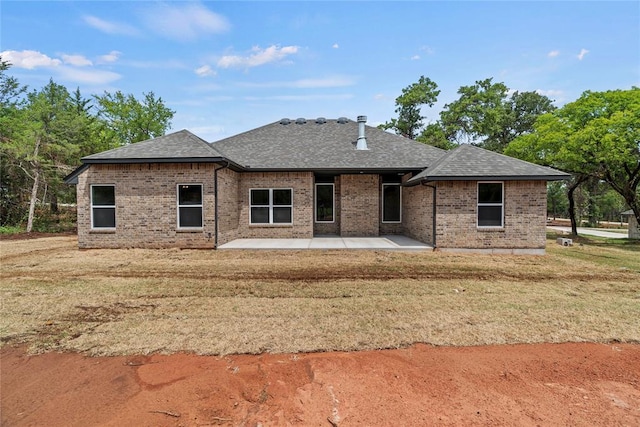 1244 Layla Ln, Blanchard, OK 73010 - back of house with brick siding, a patio, a shingled roof, and a yard