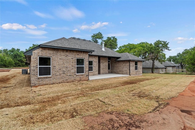 1244 Layla Ln, Blanchard, OK 73010 - back of property with a patio, a shingled roof, a lawn, and brick siding