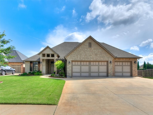 609 Newport Bridge Dr, Edmond, OK 73034 - view of front facade featuring a garage, driveway, a shingled roof, and stone siding