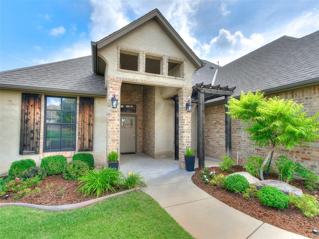 609 Newport Bridge Dr, Edmond, OK 73034 - property entrance with a pergola, roof with shingles, and stucco siding