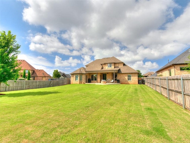 609 Newport Bridge Dr, Edmond, OK 73034 - back of property featuring brick siding, a fenced backyard, and a patio