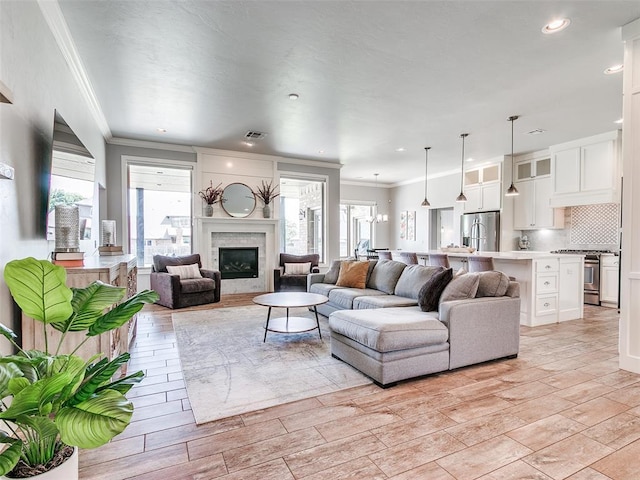 609 Newport Bridge Dr, Edmond, OK 73034 - living room featuring ornamental molding, a glass covered fireplace, and recessed lighting