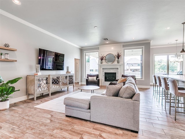 609 Newport Bridge Dr, Edmond, OK 73034 - living room featuring a glass covered fireplace, crown molding, light wood-style floors, and recessed lighting