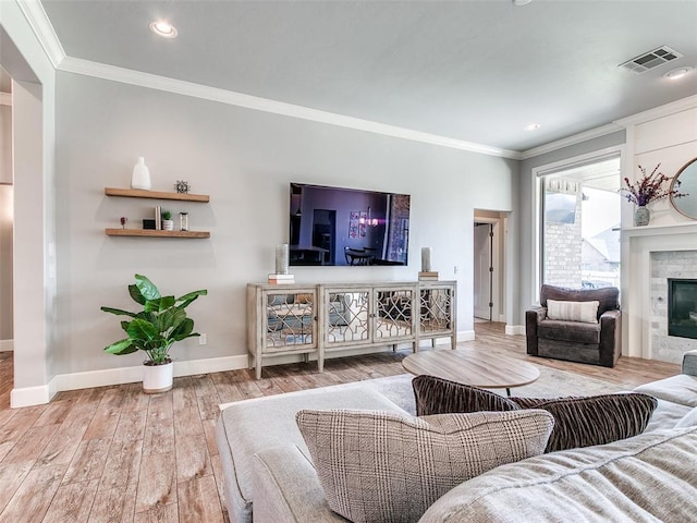 609 Newport Bridge Dr, Edmond, OK 73034 - living area featuring crown molding, wood finished floors, a glass covered fireplace, and recessed lighting