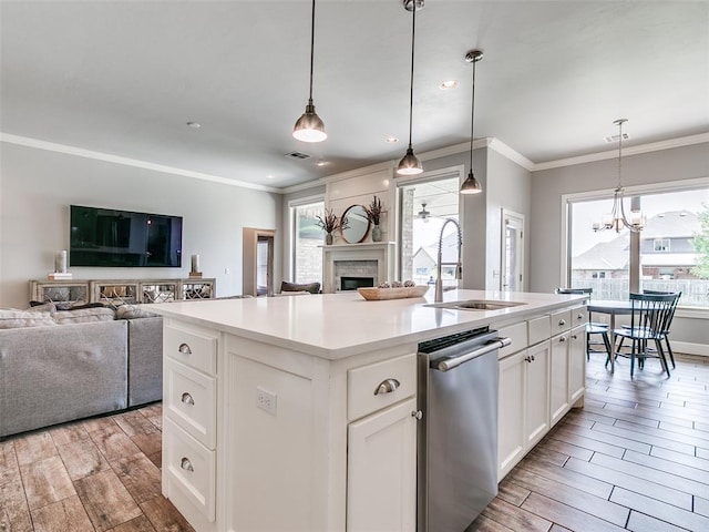 609 Newport Bridge Dr, Edmond, OK 73034 - kitchen featuring stainless steel dishwasher, open floor plan, a fireplace, light wood-type flooring, and ornamental molding