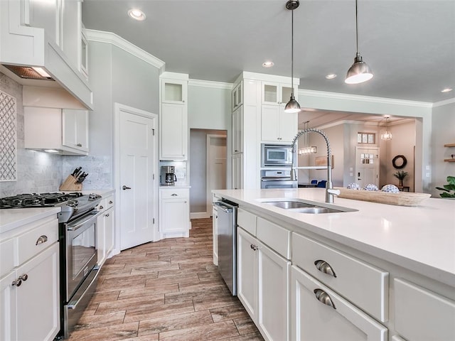 609 Newport Bridge Dr, Edmond, OK 73034 - kitchen with stainless steel appliances, crown molding, white cabinetry, light countertops, and decorative light fixtures