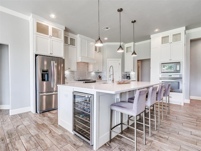 609 Newport Bridge Dr, Edmond, OK 73034 - kitchen with appliances with stainless steel finishes, wine cooler, white cabinets, light wood-type flooring, and recessed lighting