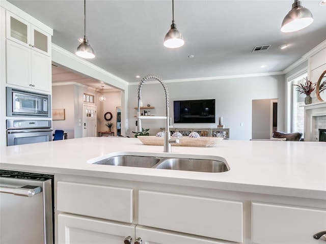 609 Newport Bridge Dr, Edmond, OK 73034 - kitchen featuring appliances with stainless steel finishes, ornamental molding, open floor plan, light countertops, and white cabinetry