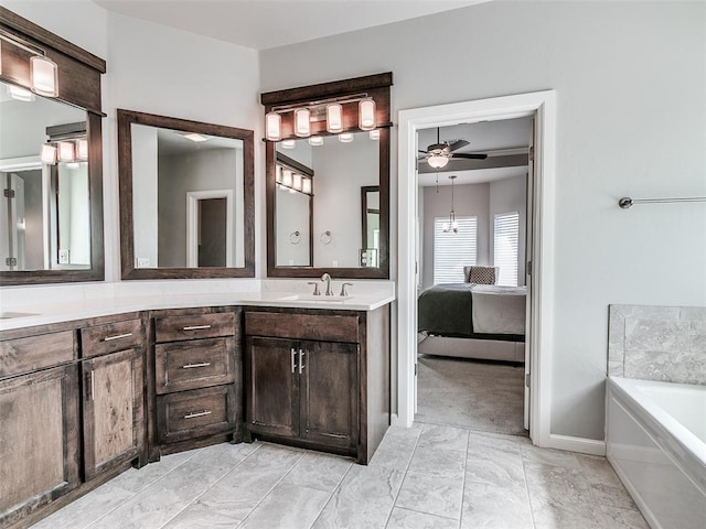 609 Newport Bridge Dr, Edmond, OK 73034 - ensuite bathroom featuring double vanity, a ceiling fan, a bath, and marble look tiles