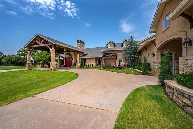 1701 Woodhill Rd, Edmond, OK 73025 - view of front of property featuring a chimney, stone siding, a front yard, stucco siding, and a shingled roof