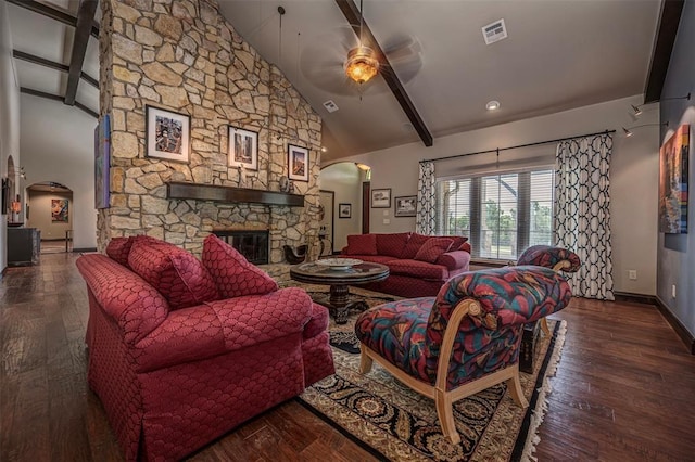 1701 Woodhill Rd, Edmond, OK 73025 - living area featuring arched walkways, a ceiling fan, hardwood / wood-style floors, a stone fireplace, and beam ceiling