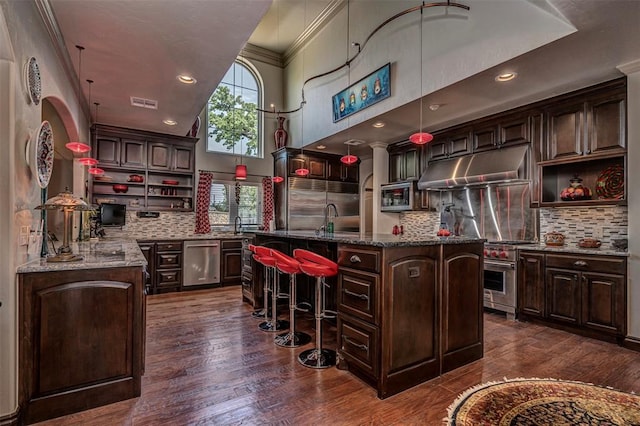 1701 Woodhill Rd, Edmond, OK 73025 - kitchen with under cabinet range hood, open shelves, a towering ceiling, an island with sink, and decorative backsplash
