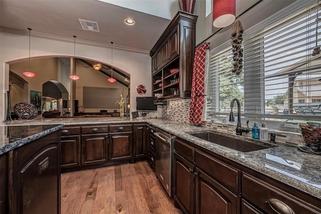 1701 Woodhill Rd, Edmond, OK 73025 - kitchen with wood finished floors, dark stone counters, dark brown cabinetry, hanging light fixtures, and recessed lighting