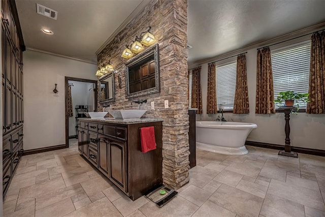 1701 Woodhill Rd, Edmond, OK 73025 - full bathroom with vanity, a soaking tub, crown molding, and stone tile floors