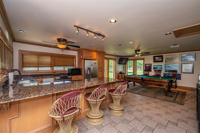 1701 Woodhill Rd, Edmond, OK 73025 - kitchen with stainless steel fridge, ceiling fan, black microwave, a peninsula, and dark stone countertops