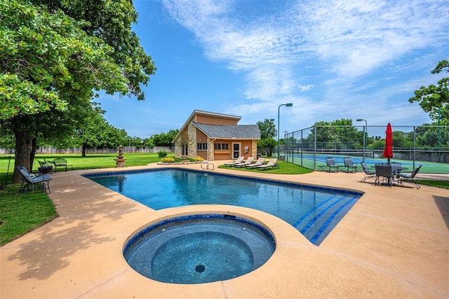 1701 Woodhill Rd, Edmond, OK 73025 - view of swimming pool with a tennis court, a pool with connected hot tub, an outbuilding, and a patio area