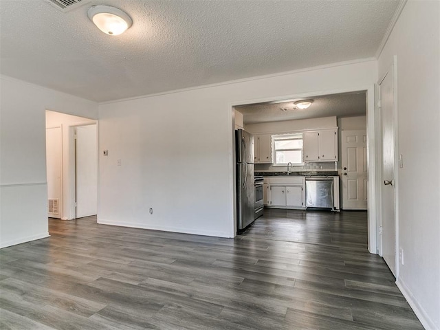 650 NW 5th St, Moore, OK 73160 - unfurnished living room featuring a textured ceiling and dark wood finished floors