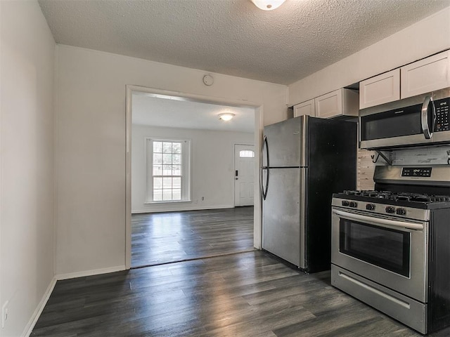 650 NW 5th St, Moore, OK 73160 - kitchen featuring appliances with stainless steel finishes, dark wood-style flooring, a textured ceiling, and white cabinetry