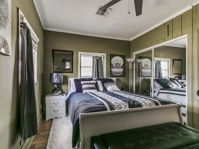 650 NW 5th St, Moore, OK 73160 - bedroom featuring multiple windows, ornamental molding, wood finished floors, a textured ceiling, and a ceiling fan