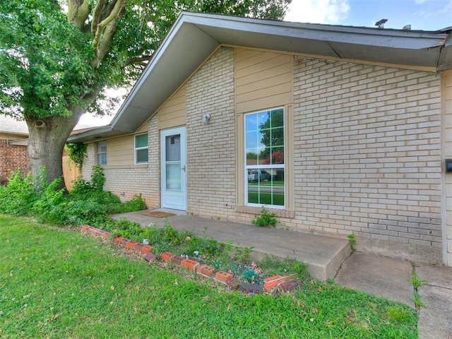 650 NW 5th St, Moore, OK 73160 - property entrance with brick siding and a yard