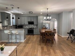 1727 NW 31st St, Oklahoma City, OK 73118 - kitchen with stainless steel fridge with ice dispenser, range, a breakfast bar, range hood, and backsplash
